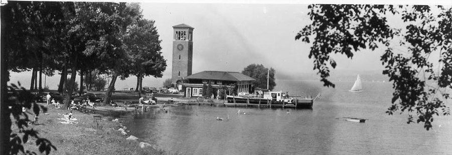 An old black and white photo of people at the beach by the Miller Bell Tower