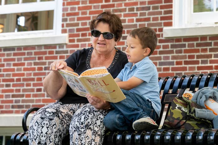 Grandmother and grandson reading a book outside the library