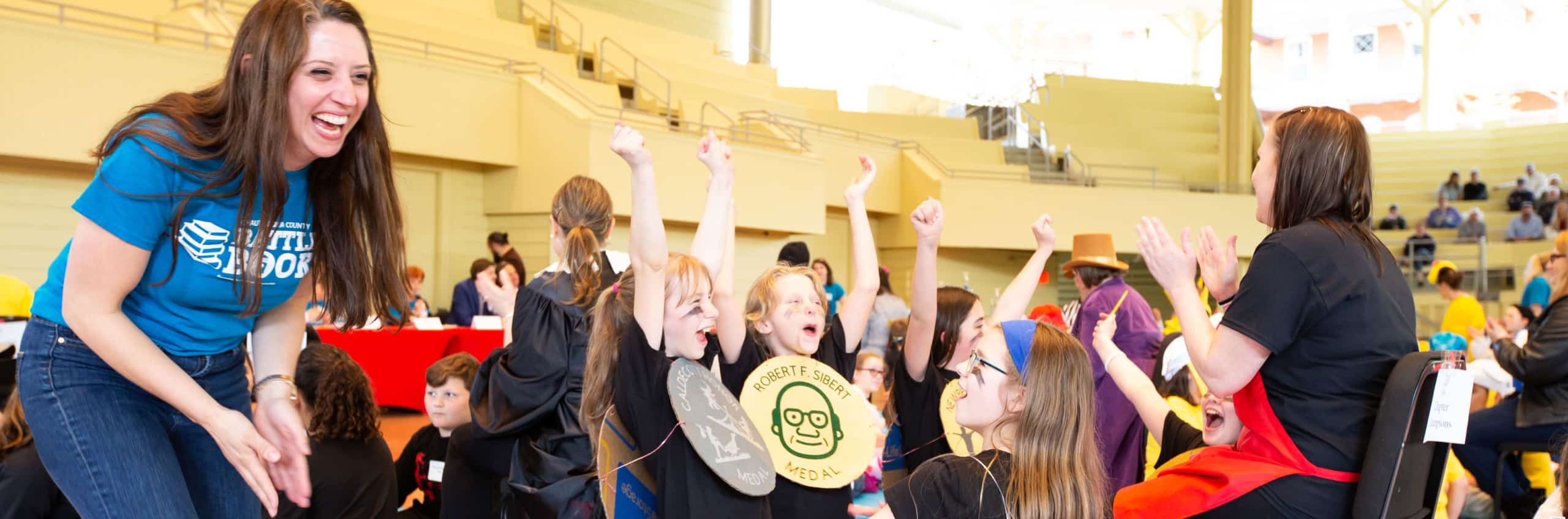 Children cheering during the Battle of the Books event in the amphitheater