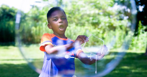 A young boy playing with bubbles at Boys' and Girls' Club