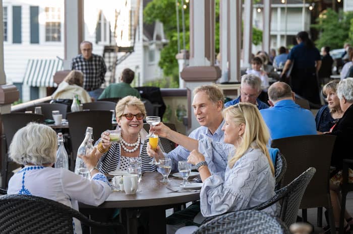 People enjoying dinner on the porch of the Athenaeum Hotel