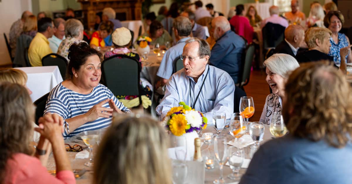 People talking at a table during a culinary event