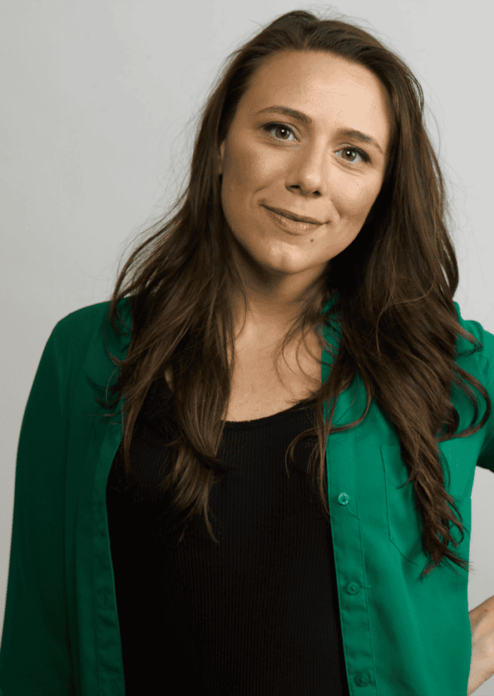 Ceci Fernandez headshot. She has long brown hair and is wearing a green sweater and black shirt.