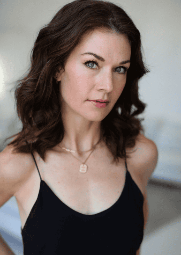 Janie Brookshire headshot. She has short brown hair and is wearing a black tank top.