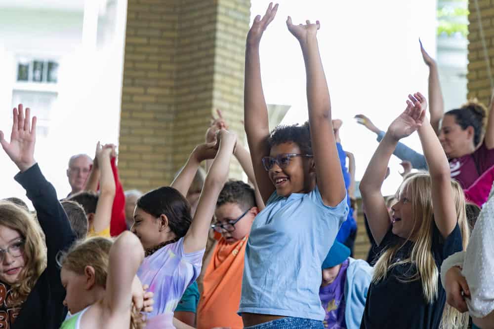 Students raising their hands and cheering