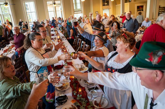 Guests clinking glasses at an Oktoberfest dinner