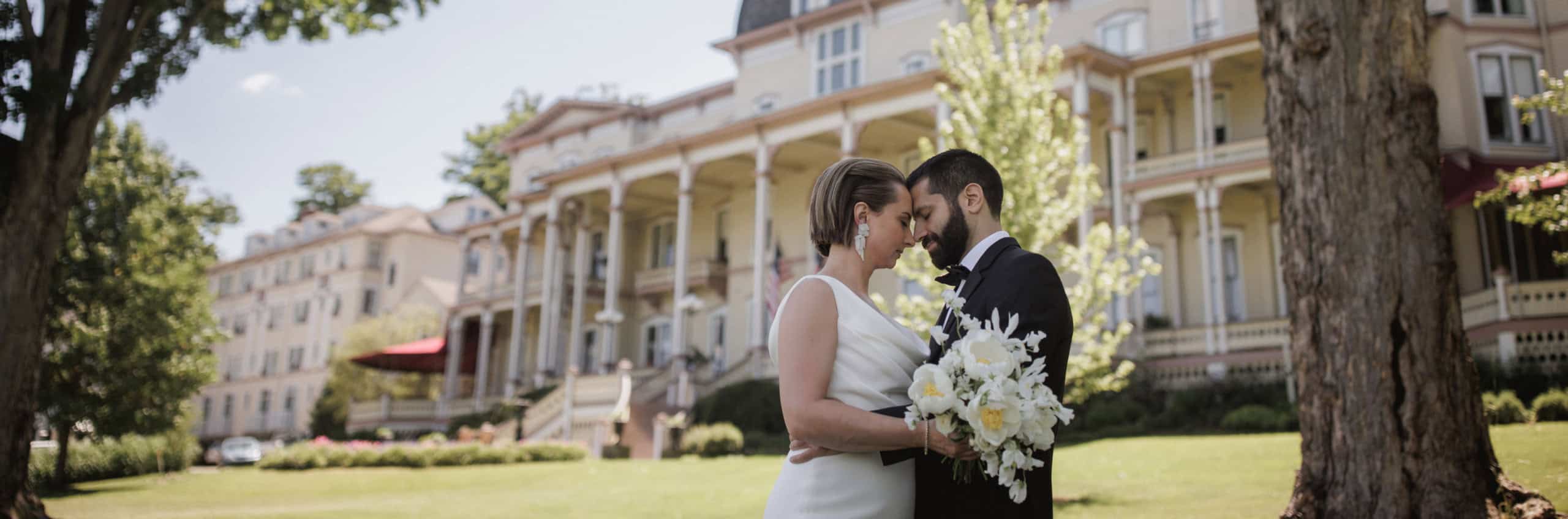 A bride and groom posing in front of the Athenaeum Hotel