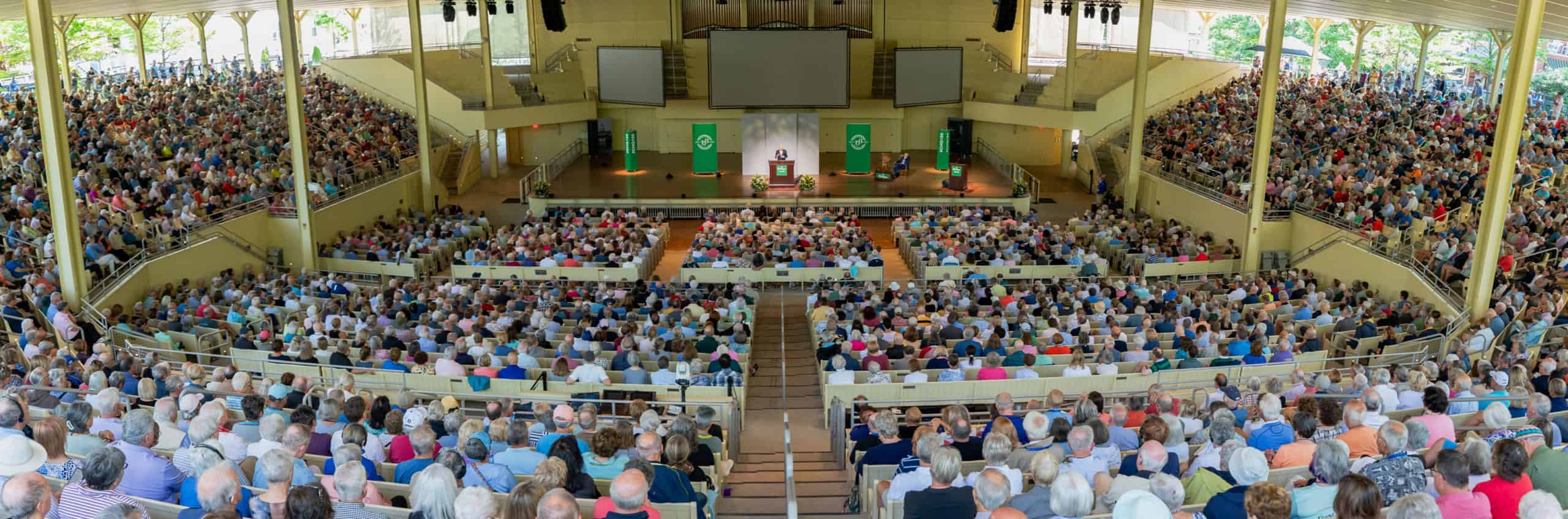 A crowded Amphitheater listening to Jon Meacham give a lecture