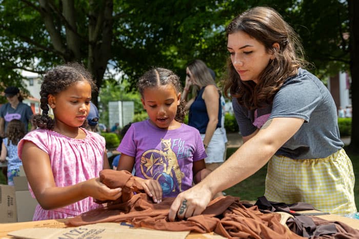 A group of girls cutting fabric and cardboard