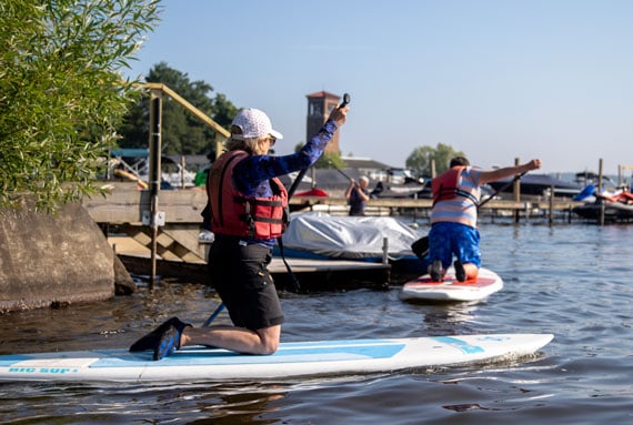 People on stand up paddle boards near the Bell Tower