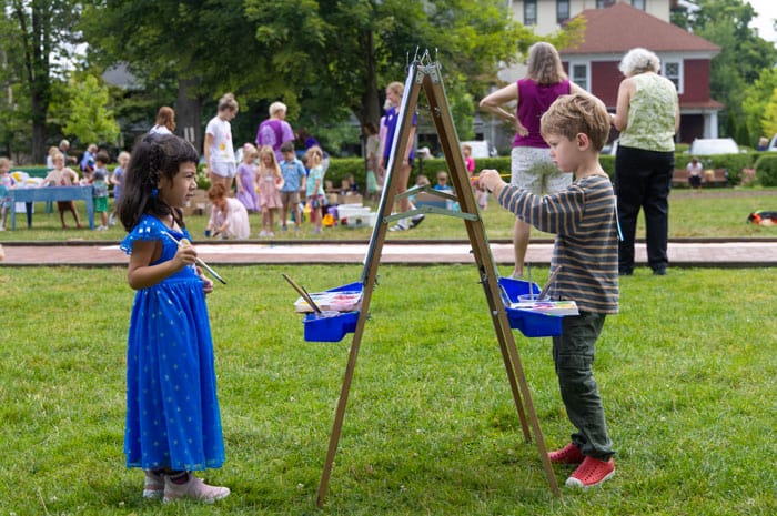 Children painting on a easel in a park