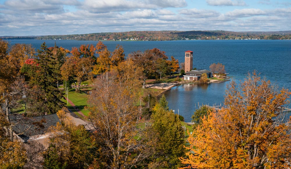 An aerial view of the bell tower and Chautauqua Lake during the fall