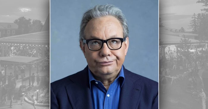 Lewis Black in a navy suit and black glasses