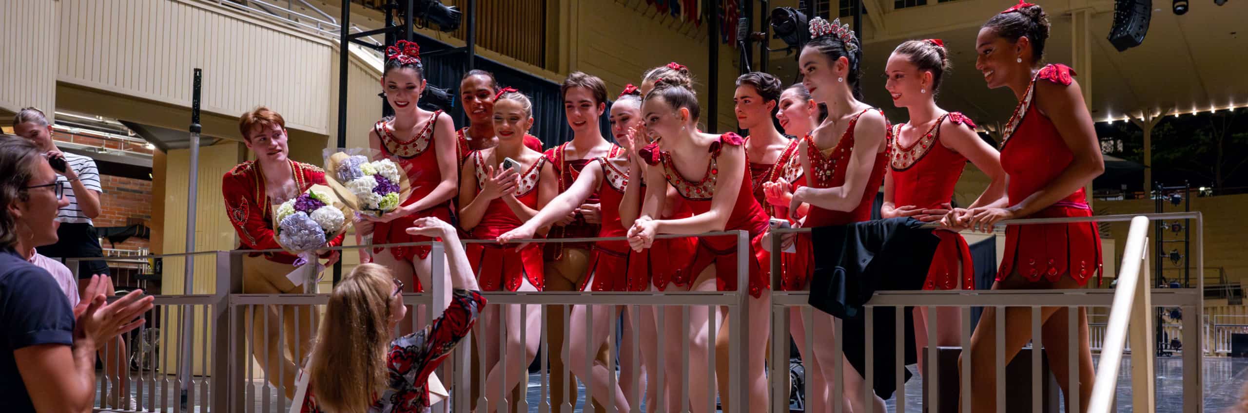 A faculty member congratulating dancers after a performance