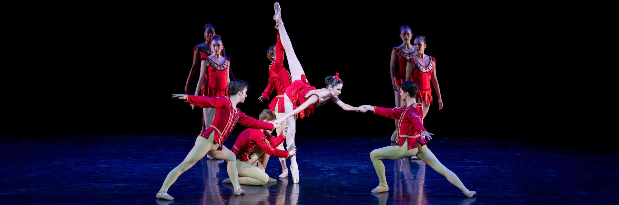 Dancers on stage in red costumes