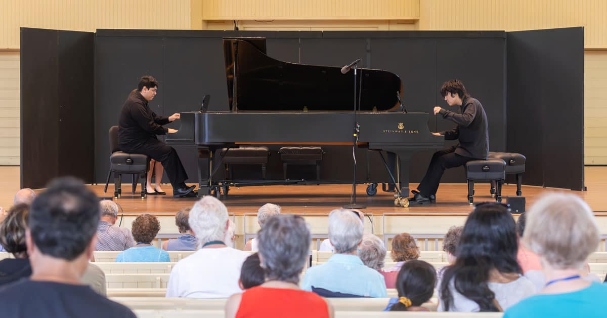 Two piano students performing on stage