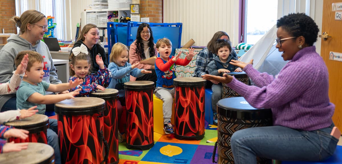 A teaching artist leading a drumming circle in a classroom